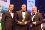 Steve Stewart, Dir. Europ. Branch Operations bei Crown, erhält von Derek Anderson, Manbat Ind. Power Systems (li), und Moderator Gyles Brandreth (re) den FLTA 2016 Archie Award for Ergonomics.